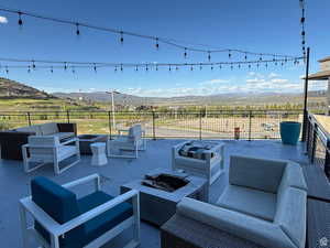View of patio with an outdoor living space with a fire pit and a mountain view