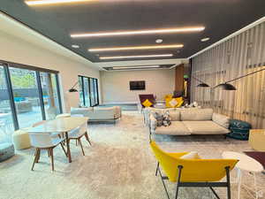 Carpeted living room featuring wooden walls