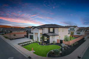 View of front of house with a garage, concrete driveway, stucco siding, and a tiled roof