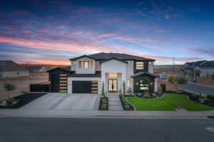 Modern home with concrete driveway, a standing seam roof, a metal roof, and a garage