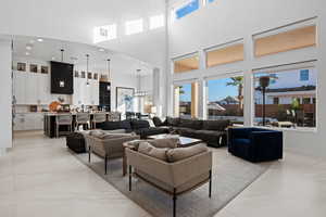 Living room with a high ceiling, recessed lighting, arched walkways, and light marble finish floors