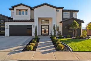 Contemporary house with a garage, brick siding, a standing seam roof, and driveway