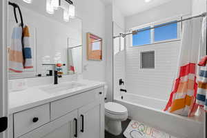 Full bath with shower / tub combo with curtain and vanity