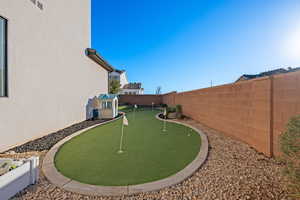 Fenced backyard with an area to practice putting