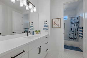 Full bath featuring shower / bathtub combination with curtain, vanity, and light tile patterned floors