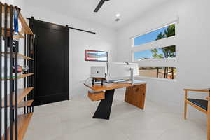Home office featuring a barn door, ceiling fan, and recessed lighting