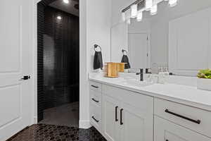 Bathroom with vanity, a stall shower, and dark tile patterned flooring