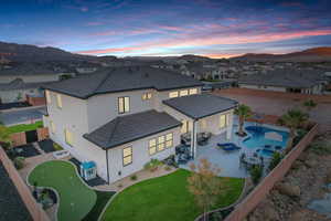 Back of house featuring a fenced backyard, a patio area, a putting area, and a residential view