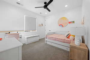 Carpeted bedroom featuring ceiling fan and recessed lighting