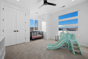 Bedroom featuring a crib, carpet, recessed lighting, a ceiling fan, and a closet