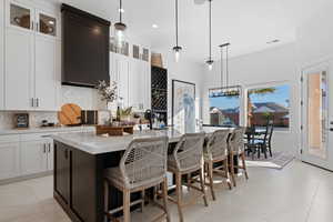 Kitchen with white cabinetry, tasteful backsplash, pendant lighting, glass insert cabinets, and recessed lighting