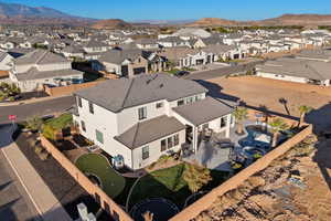 Aerial view of property and surrounding area featuring a mountainous background