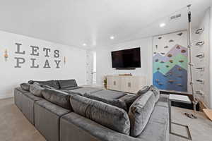 Carpeted living area with recessed lighting and a textured ceiling