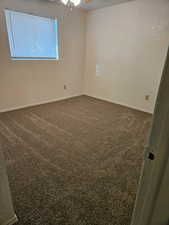 Basement Bedroom with dark carpet and baseboards
