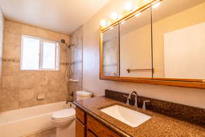 Bathroom featuring tub/shower combination, vanity, and tile flooring
