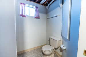 Half bath with toilet and baseboards