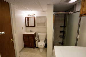 Second Bath (downstairs) featuring a shower stall, a drop ceiling, vanity, washer and dryer