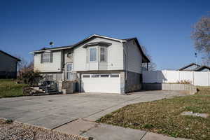 Bi-level home featuring brick, siding, driveway, and an attached garage