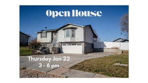 Raised ranch with an attached garage, driveway, and brick siding