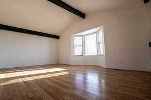 Front room featuring picture window, ceiling beams, wood flooring and baseboards