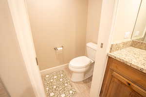 Half bath with vanity and light tile patterned flooring