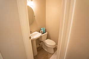 Half bathroom featuring toilet and light wood-type flooring