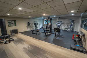 Gym featuring a paneled ceiling and recessed lighting