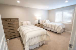 Additional en suite bedroom featuring light colored carpet and recessed lighting