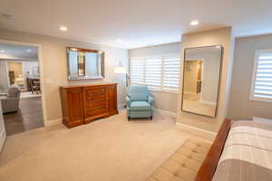Bedroom featuring light carpet, multiple windows, and recessed lighting