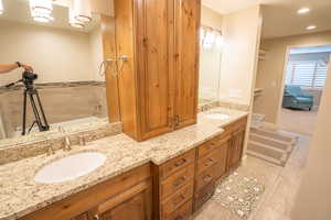 Bathroom with double vanity, a garden tub, and recessed lighting