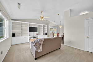 Living area with light carpet, lofted ceiling, and ceiling fan