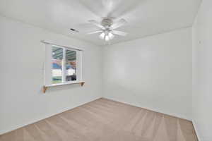 Unfurnished room featuring light carpet and a ceiling fan