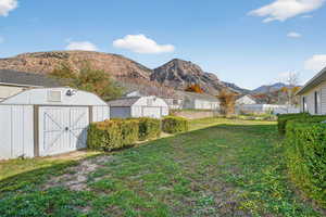View of yard with a mountain view and a storage unit