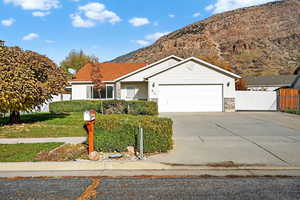 Ranch-style home featuring driveway, a mountain view, and a garage