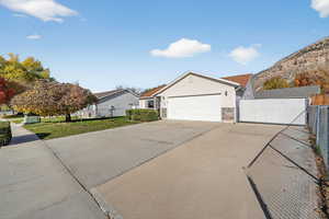Ranch-style house featuring a gate, a garage, and driveway