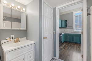 Full bathroom with vanity, decorative backsplash, and dark wood finished floors
