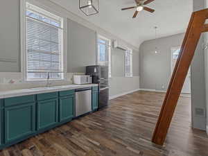 Kitchen featuring dark wood-type flooring, dishwasher, healthy amount of natural light, and a ceiling fan