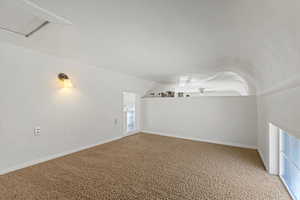 Additional living space featuring carpet and lofted ceiling