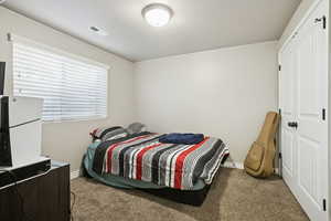 Carpeted bedroom featuring baseboards and a closet
