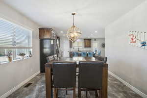 Dining space featuring recessed lighting, a chandelier, and dark stone finish floors