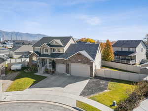 Traditional home with concrete driveway, a residential view, a garage, a mountain view, and covered porch