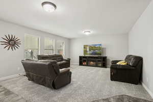 Living area featuring carpet and baseboards