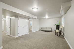 Living area with a textured ceiling and light carpet