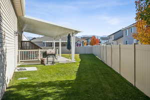 Fenced backyard featuring a patio area and a residential view