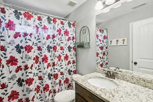 Bathroom with a shower with curtain and vanity