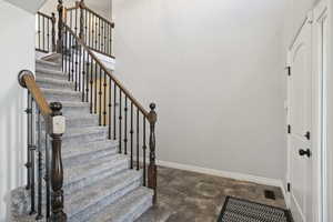 Stairway with baseboards and stone finish flooring