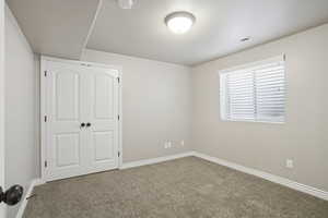 Unfurnished bedroom featuring carpet and a closet