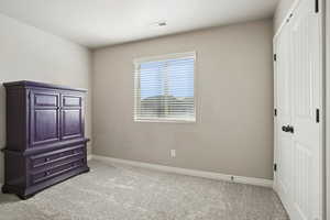 Unfurnished bedroom with a closet and light carpet