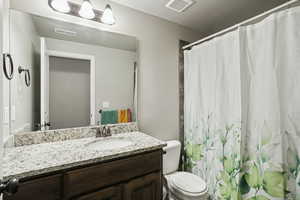 Full bathroom featuring curtained shower and vanity