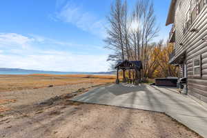 View of yard with a hot tub, a patio, and a mountain view